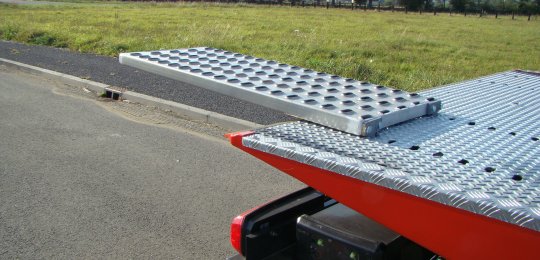 Deux rampes aluminium 1250x500 mm adaptables en bout du plateau pour permettre le débordement des roues du véhicule transporté