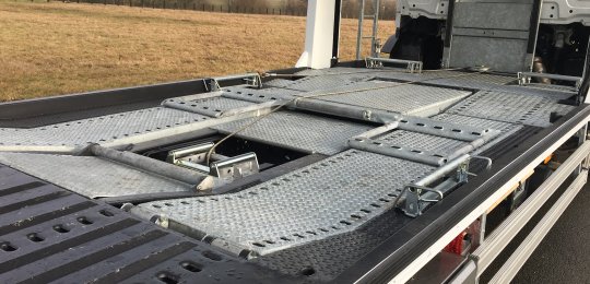 Stacking system for a 6th car with hinge on the back of the cab and rear lift with 2 hydraulics cylinders and an additional adjustment of length following the wheelbase of the vehicle