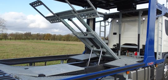 Stacking system for a 6th car with hinge on the back of the cab and rear lift with 2 hydraulics cylinders and an additional adjustment of length following the wheelbase of the vehicle